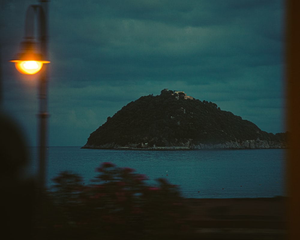 body of water near mountain during night time