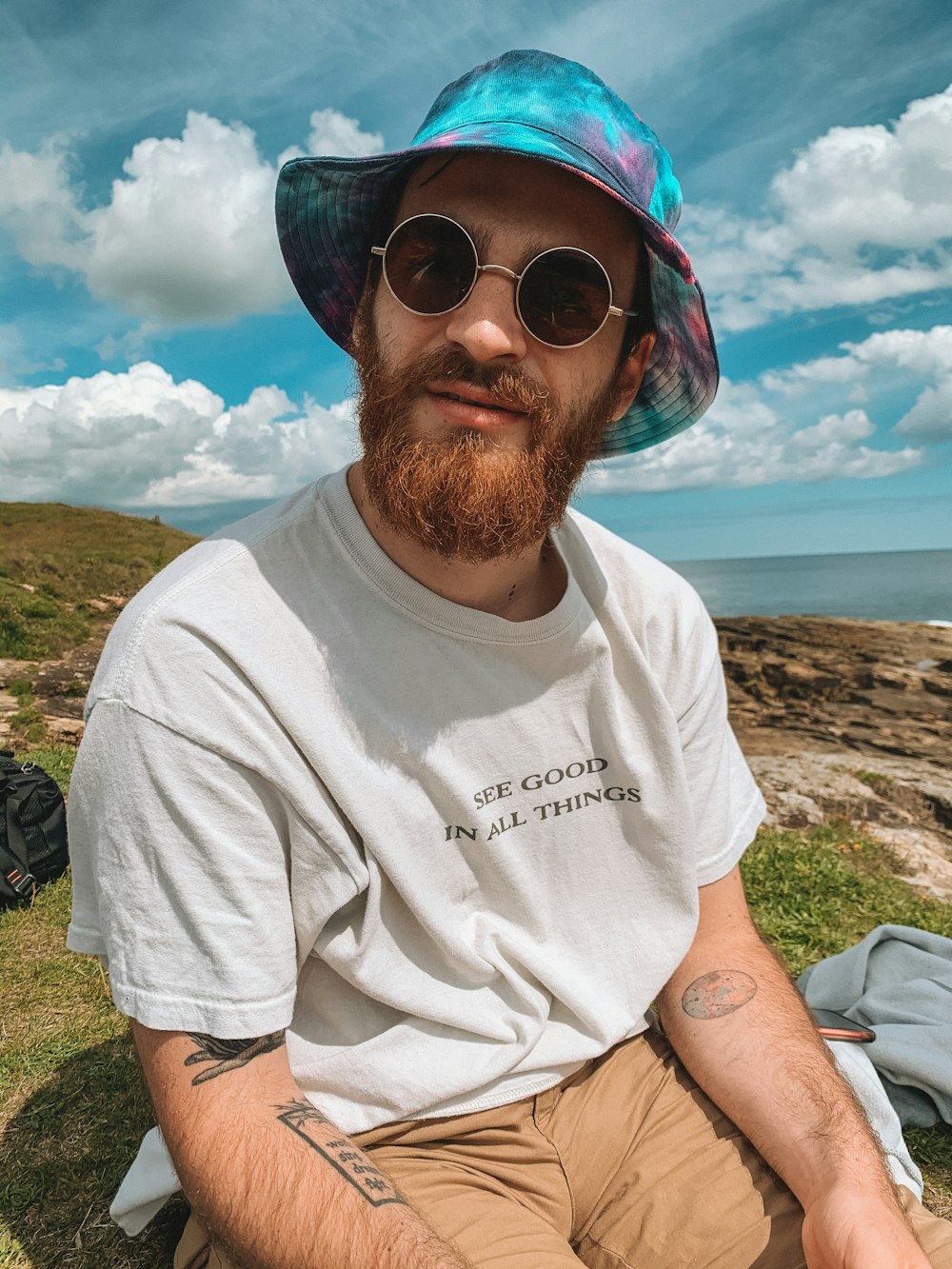 man in white crew neck t-shirt wearing blue sunglasses