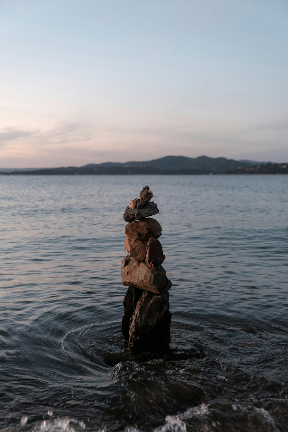 brown rock formation on body of water during daytime