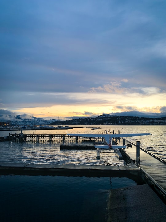 brown wooden dock on body of water during sunset in Kelowna Canada