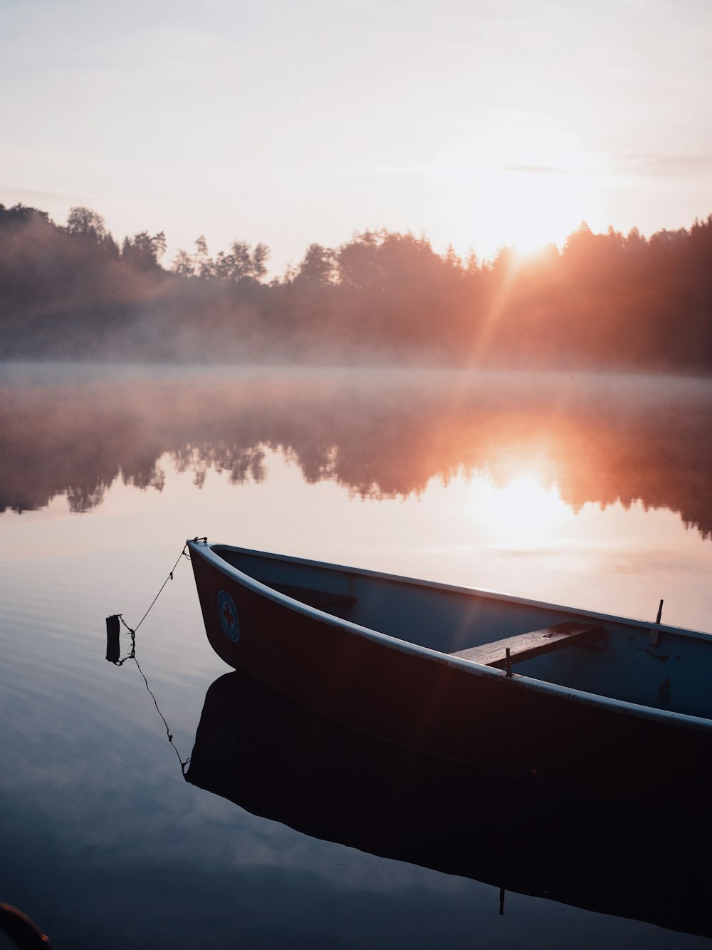 weißes und schwarzes Boot bei Sonnenuntergang auf dem Wasser