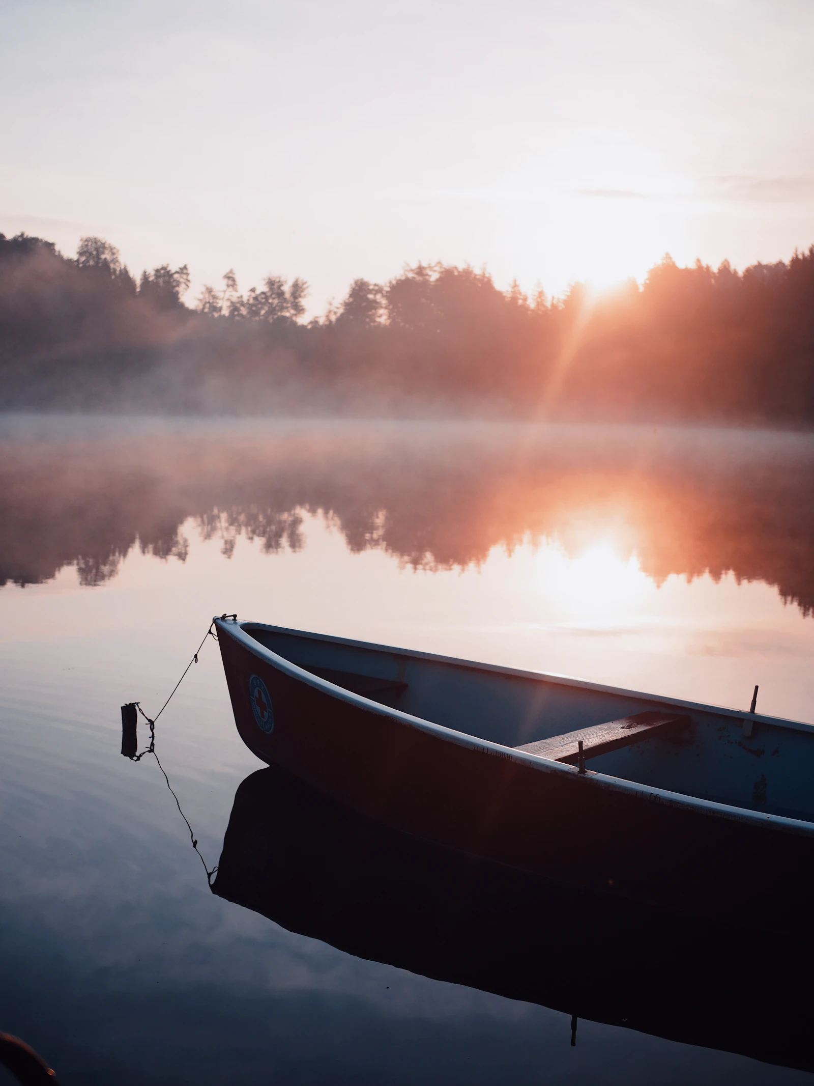 A boat on a still lake at sunrise