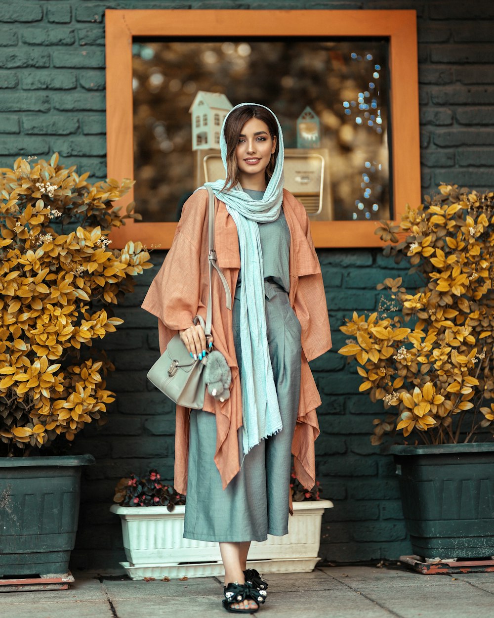 woman in blue and white long sleeve dress standing beside yellow flowers