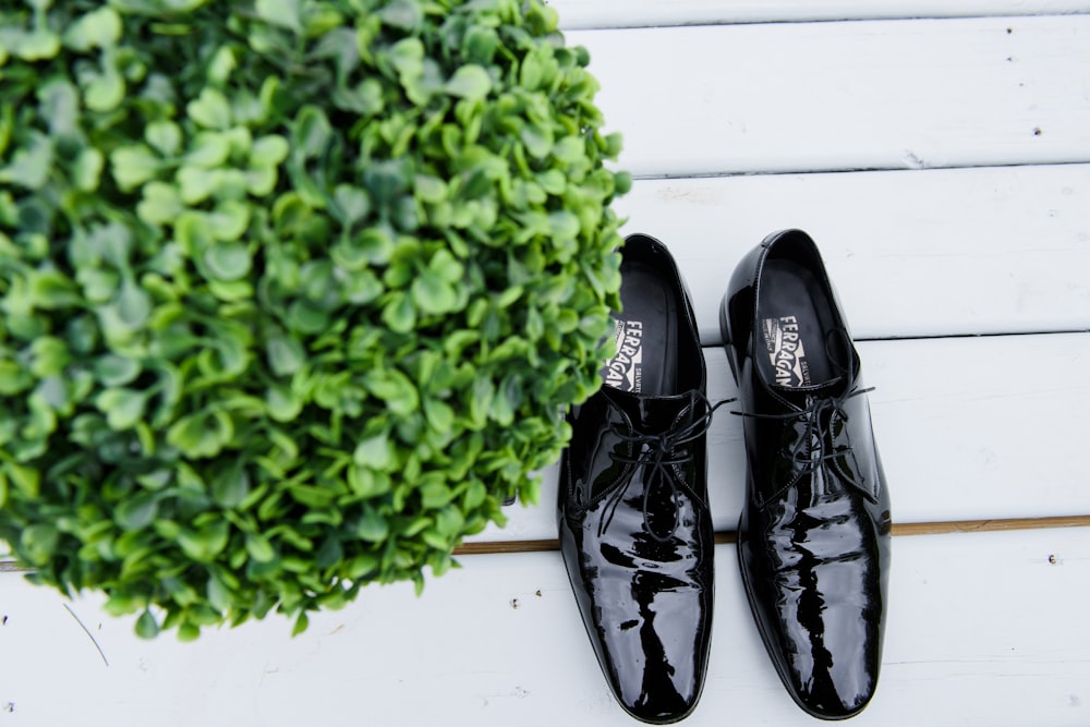 black leather shoes on white wooden table