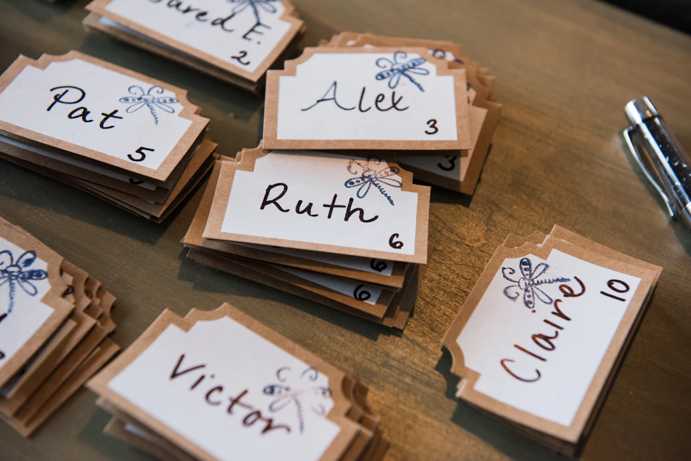 Handwritten wedding place cards laid out on a table