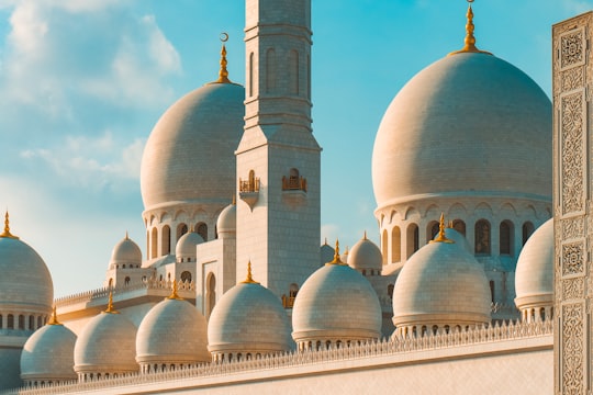 white and brown dome building under blue sky during daytime in Sheikh Zayed Mosque United Arab Emirates