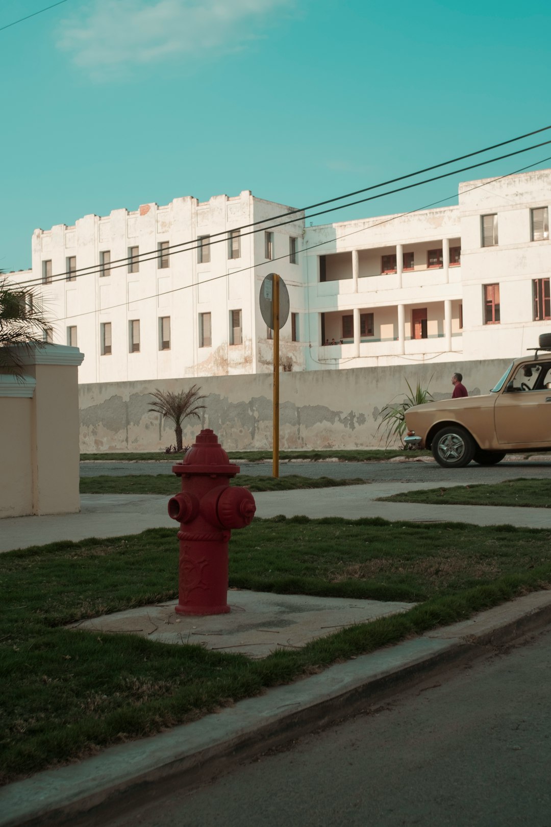 red fire hydrant near white concrete building during daytime