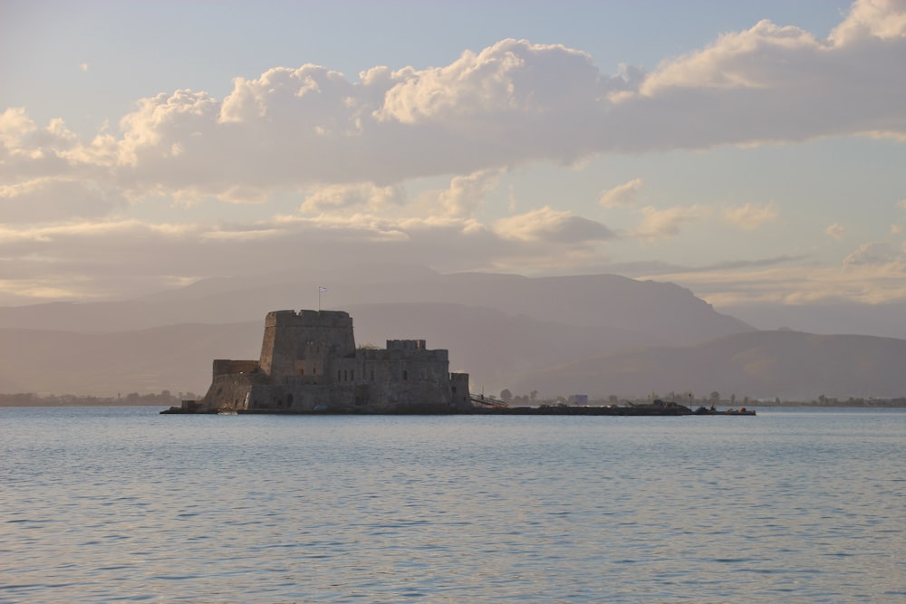 gray concrete building near body of water under white clouds during daytime