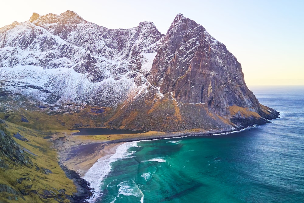 body of water near mountain during daytime