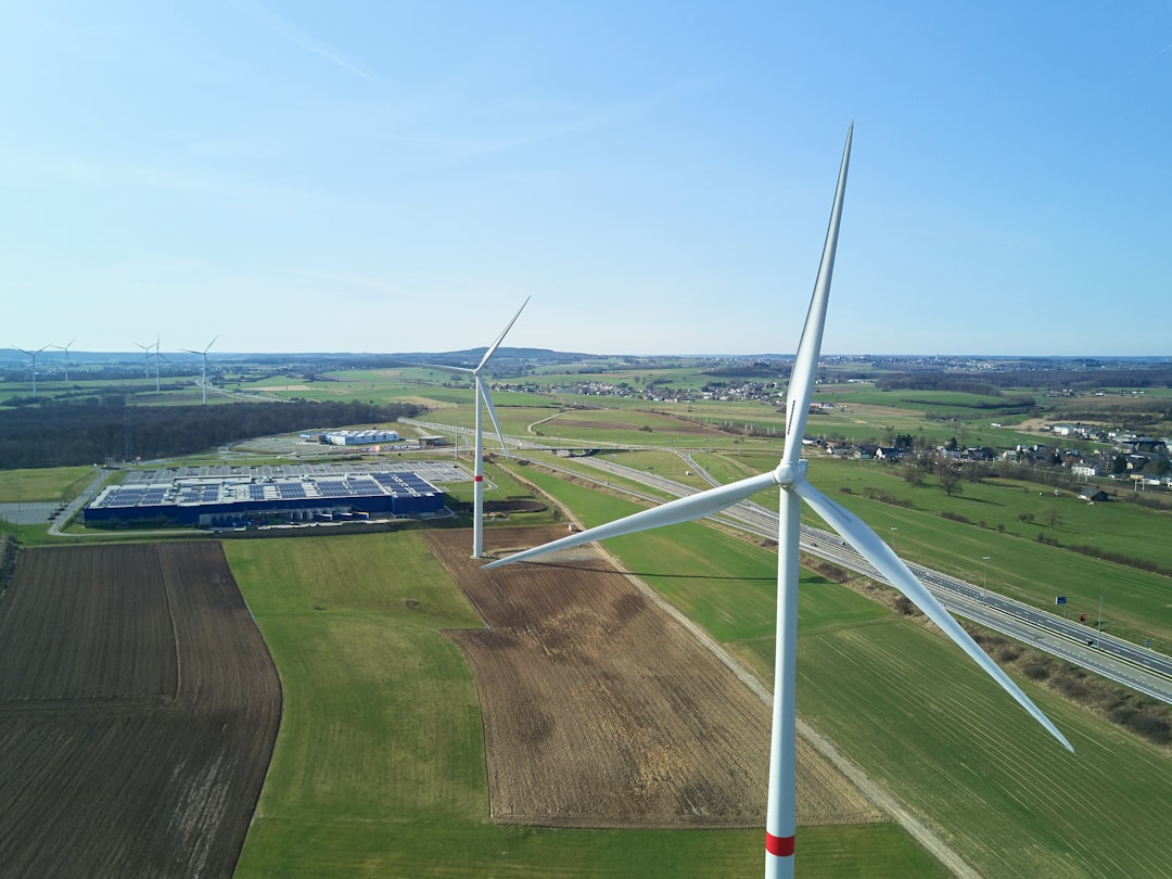 white wind turbine on green grass field during daytime