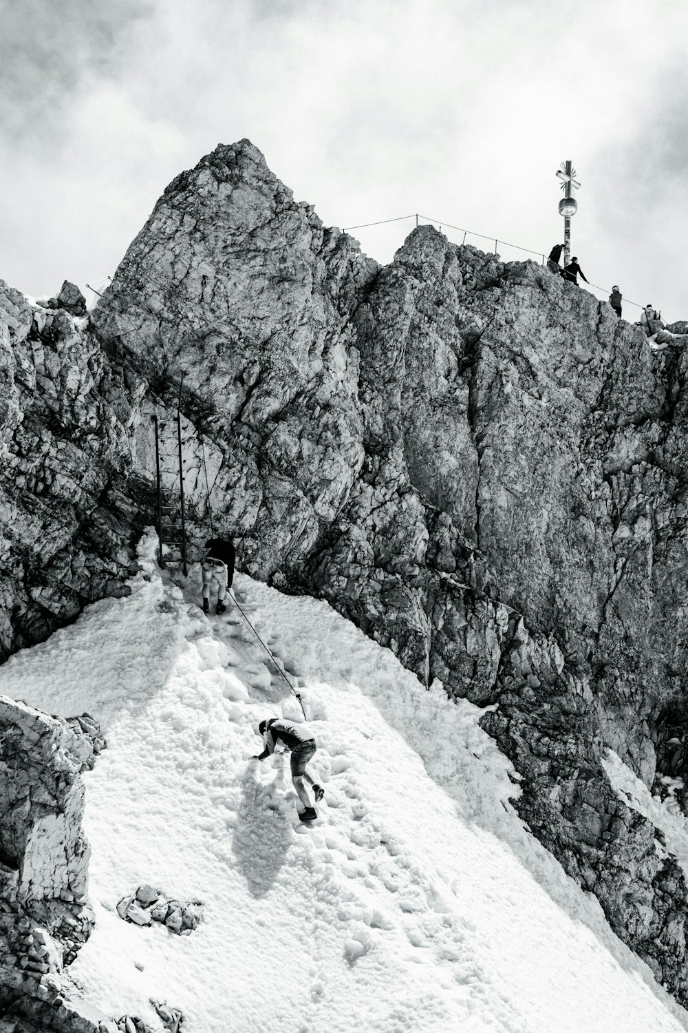 grayscale photo of person climbing on mountain