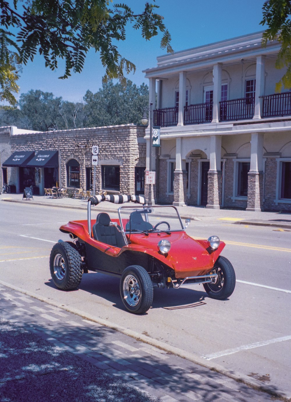 red and black ride on toy car on road during daytime