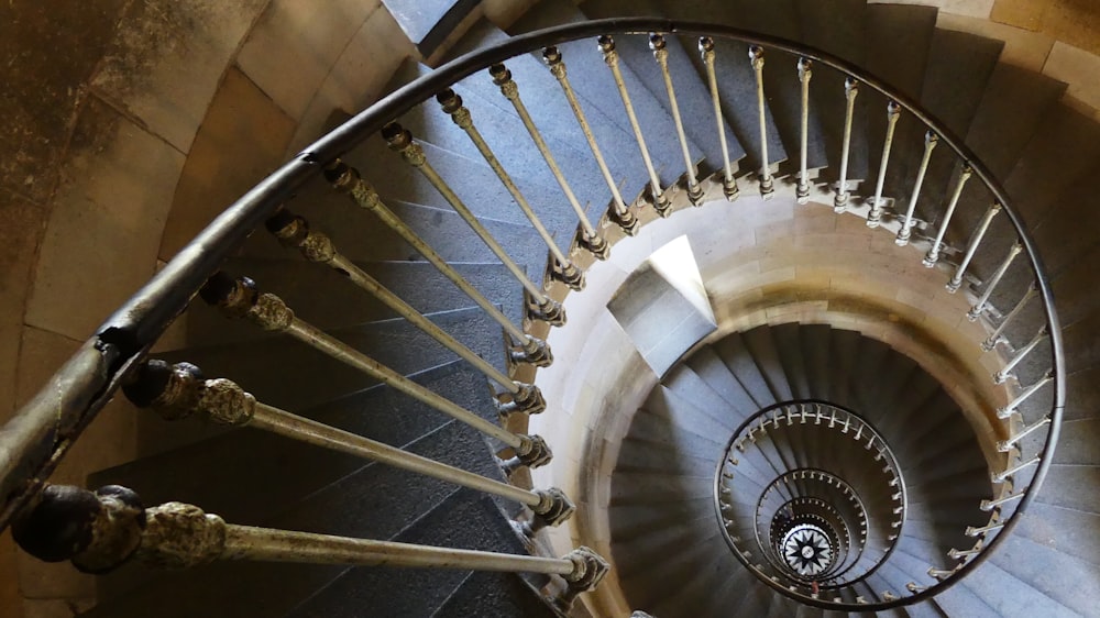 brown wooden spiral staircase with white metal railings