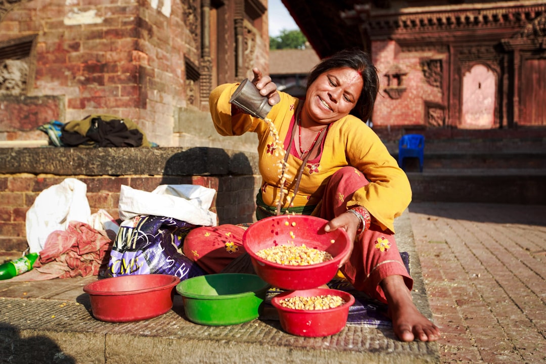 woman in yellow long sleeve shirt holding red plastic bucket