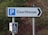 A signpost pointing towards a courthouse parking area. The main sign features a large letter 'P' indicating parking, with the word 'Courthouse' and an arrow pointing right. Below it, there is a smaller sign for accessible parking with a wheelchair symbol.