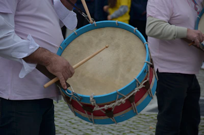 Hands playing a traditional drum alongside a modern keyboard, symbolizing musical fusion.