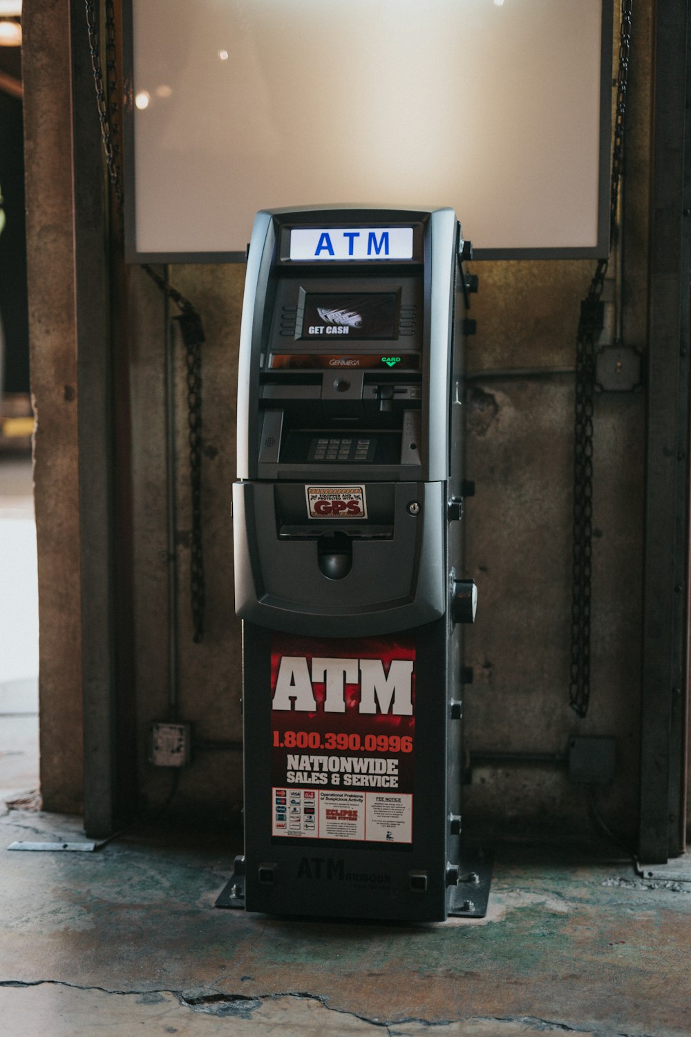 a atm machine sitting in front of a building