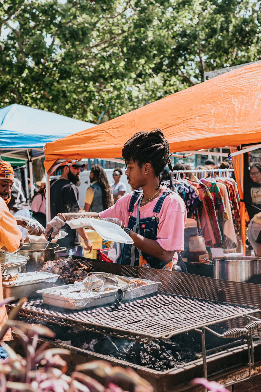 woman in pink and white crew neck t-shirt standing in front of food stall during
