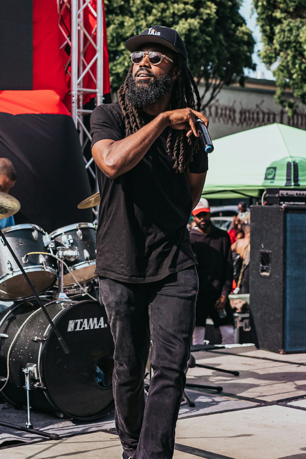 man in black t-shirt and black pants singing on stage