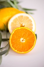 Close-up of fresh citrus fruits arranged vibrantly against a soft gray background.