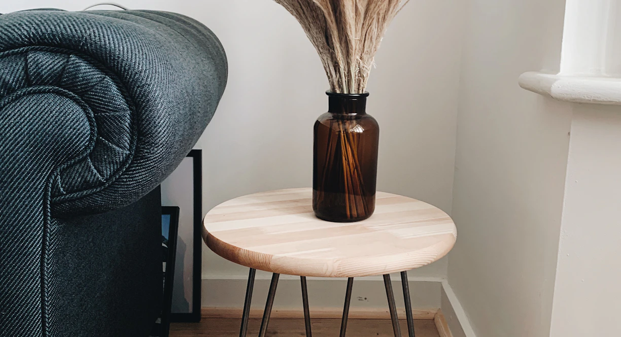 brown wooden round seat beside gray sofa