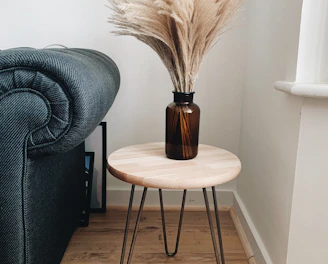 brown wooden round seat beside gray sofa