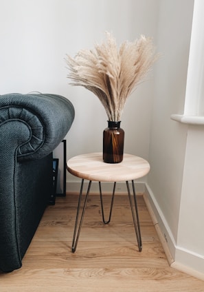 A stylish wooden table with metal legs in a cozy living room.