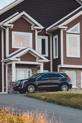 black suv parked in front of white wooden house