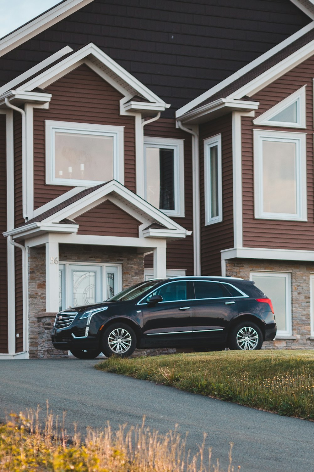 black suv parked in front of white wooden house