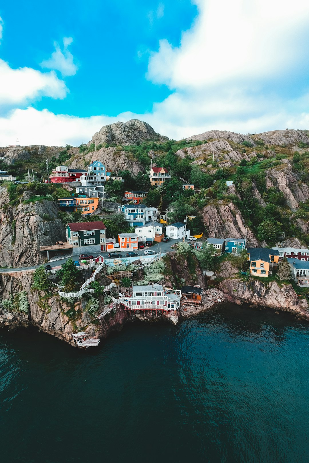 houses on mountain near body of water during daytime