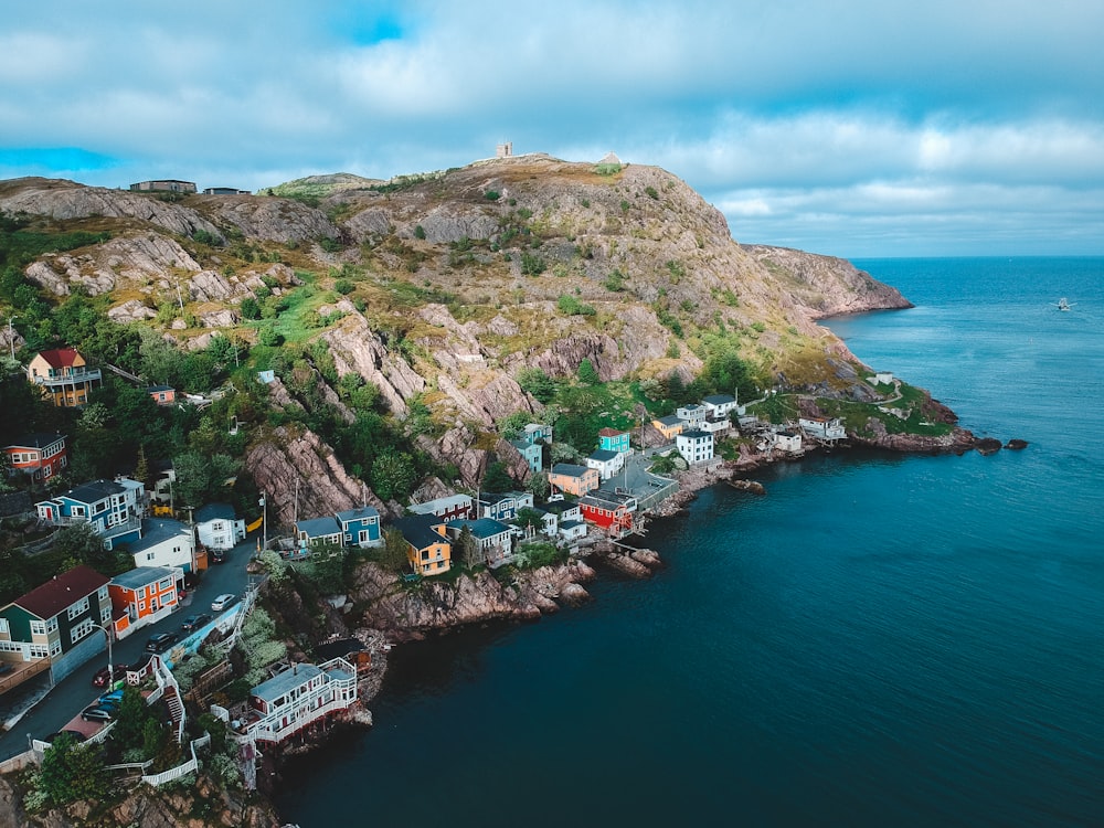 Maisons sur la montagne près d’un plan d’eau pendant la journée