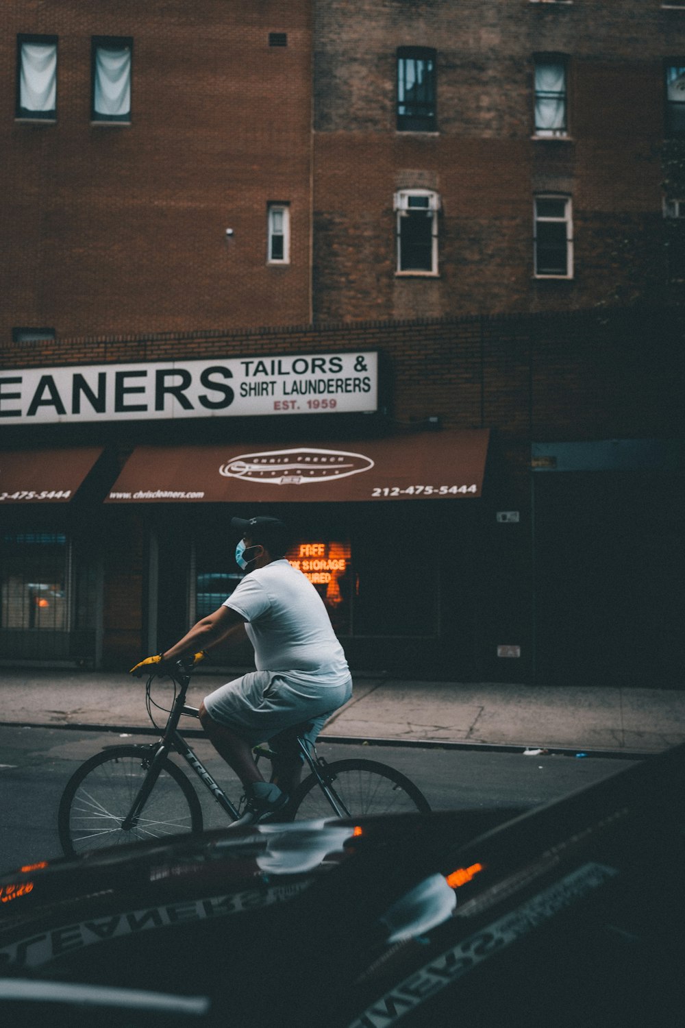 man in white shirt riding bicycle on street during daytime