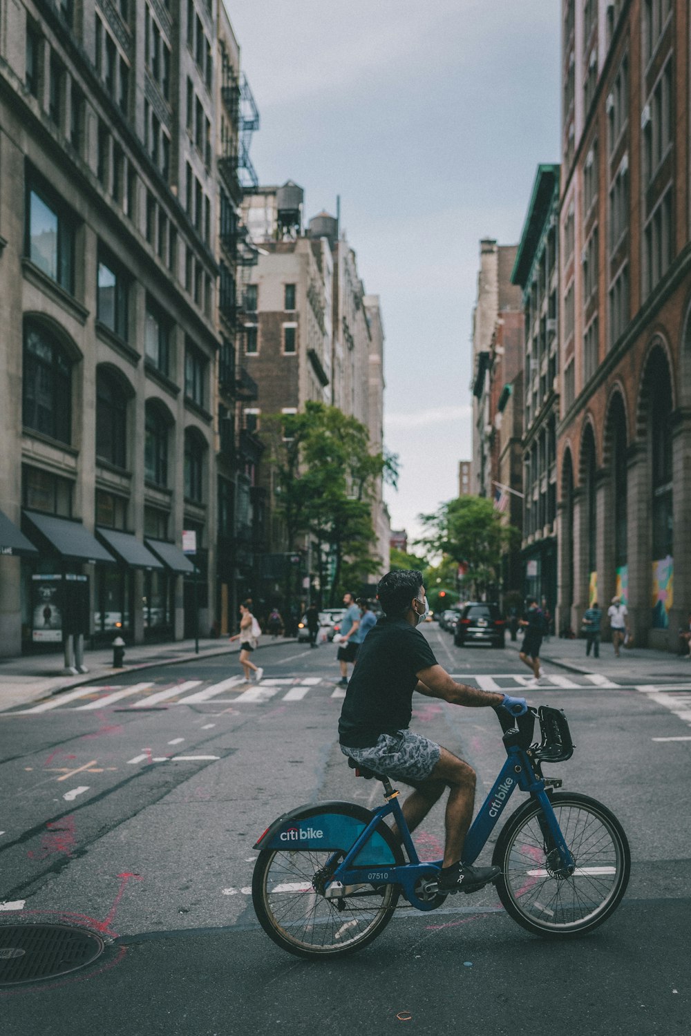 man in black jacket riding bicycle on road during daytime