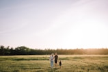 A father and daughter walking through a sunlit field, deep in conversation about the farm's future.