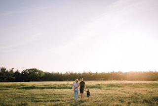 A family happily walking through a green field, envisioning their future project.