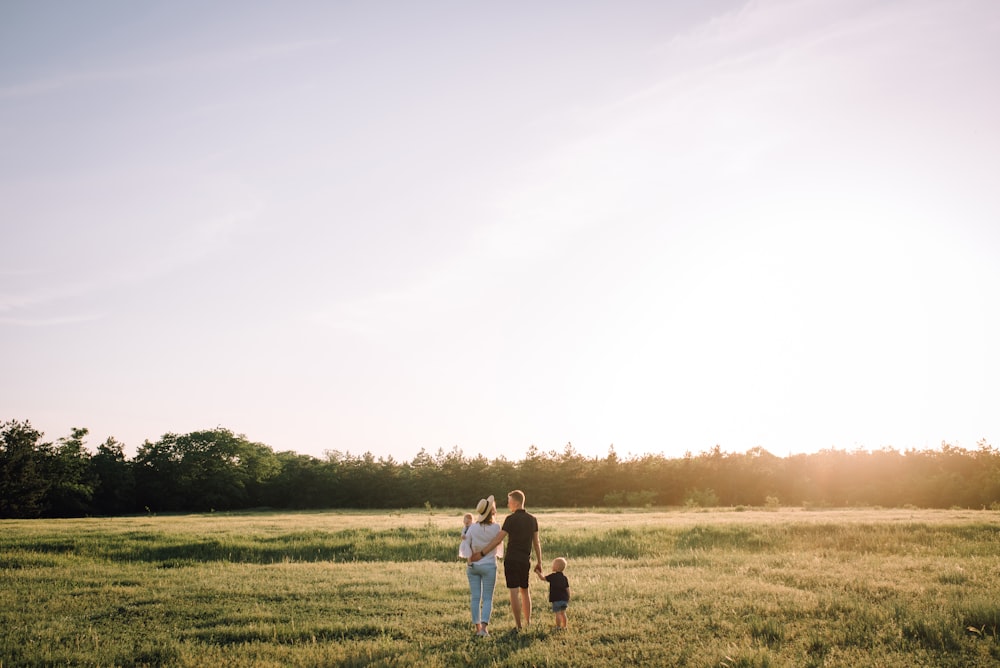 man and woman walking on green grass field during daytime