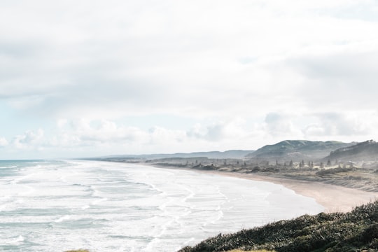 ocean waves crashing on shore during daytime in Muriwai New Zealand