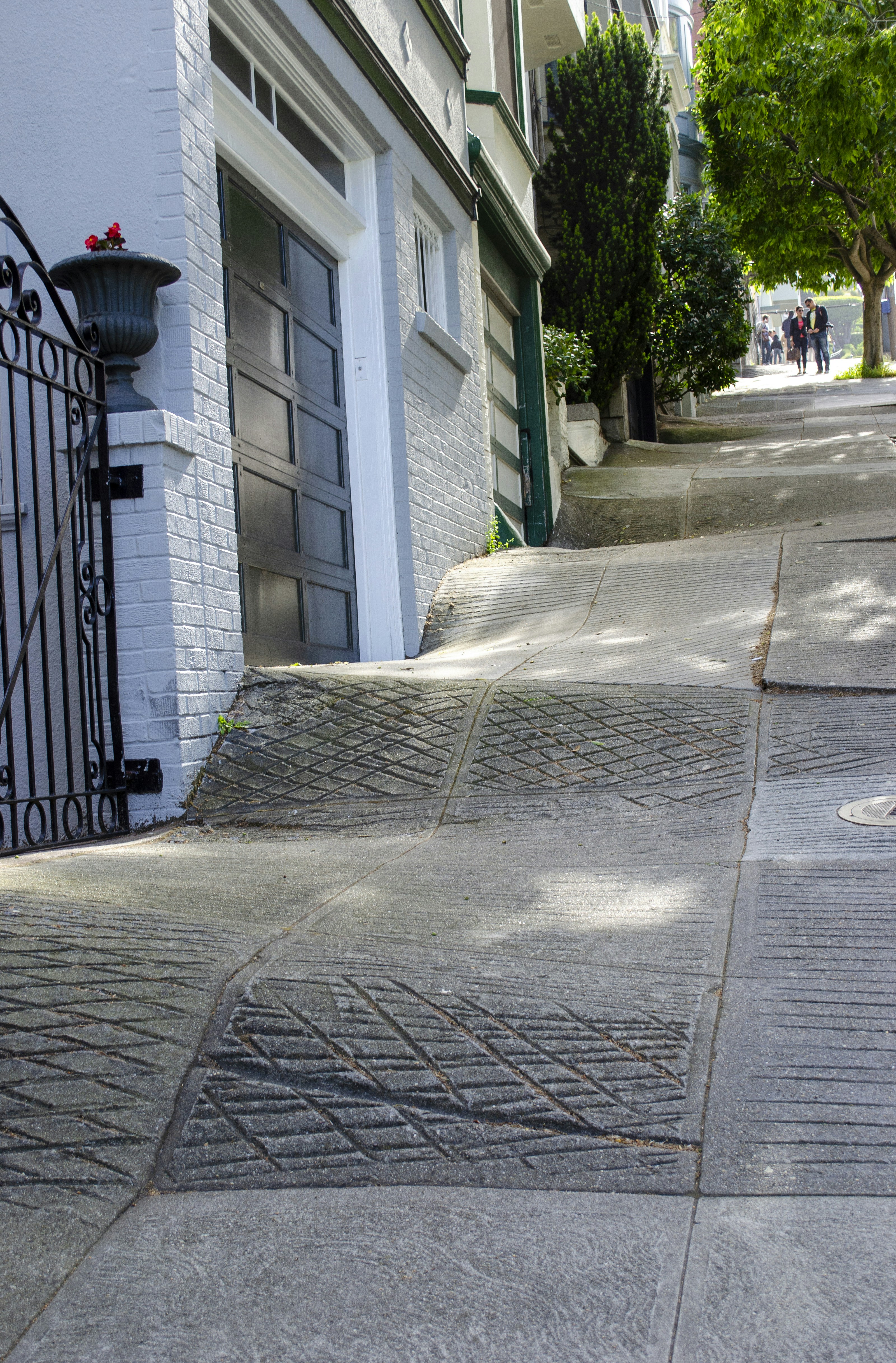 Steep and uneven sidewalk with people