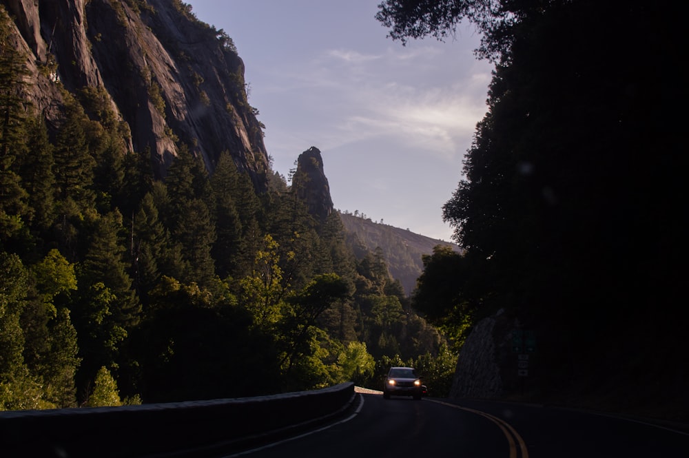 Coche negro en la carretera cerca de la montaña durante el día