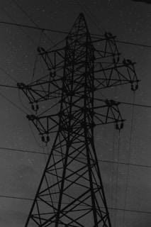 Close-up of the solar tower's battery base with visible cables and sturdy metal frame under night sky.