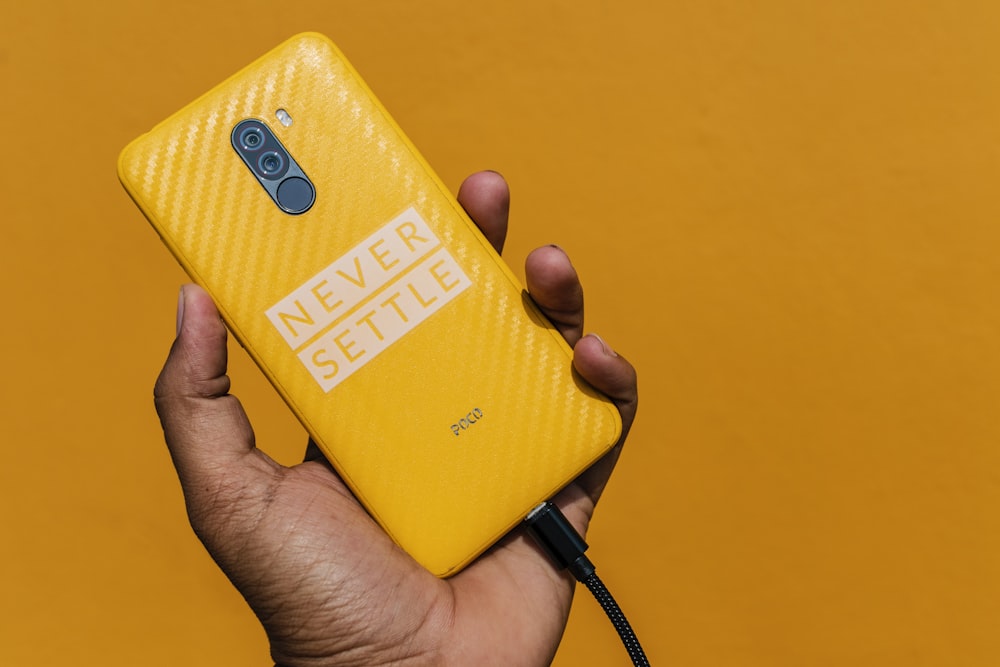 gelbes Smartphone mit schwarzem Kabel