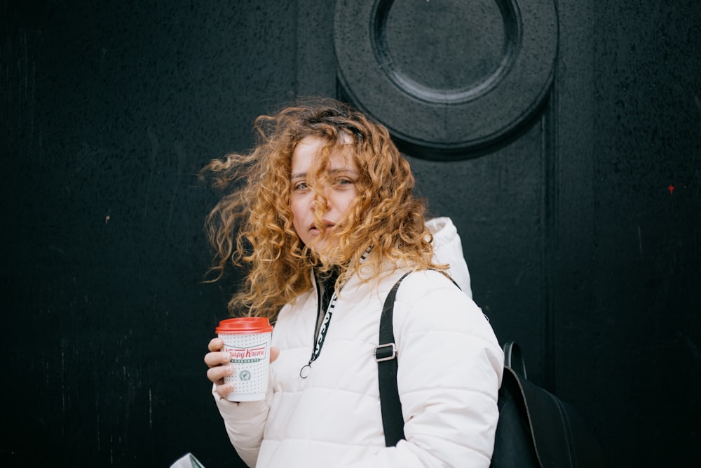 woman in white long sleeve shirt holding white ceramic mug