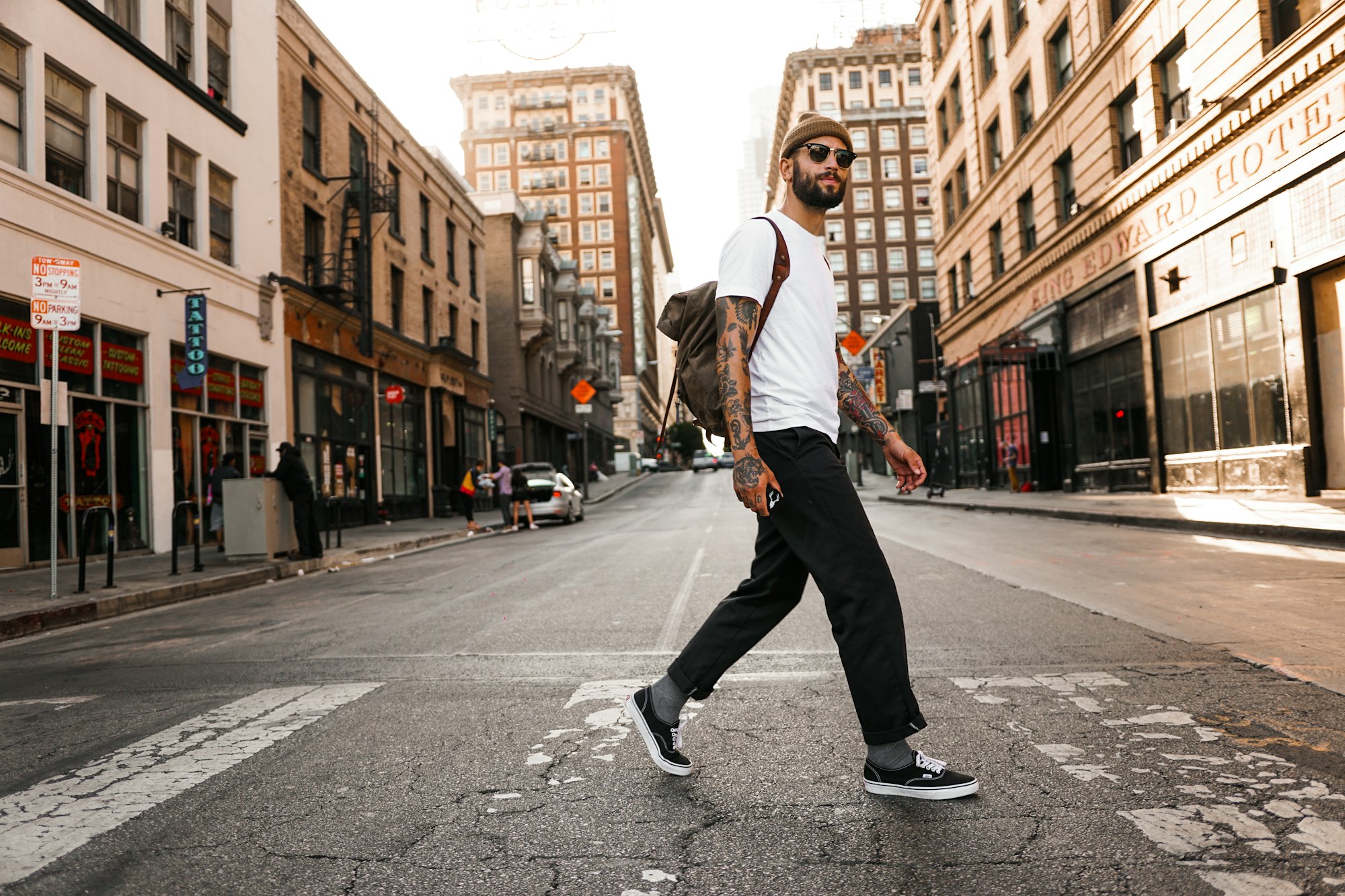 man in white long sleeve shirt and black pants standing on road during daytime