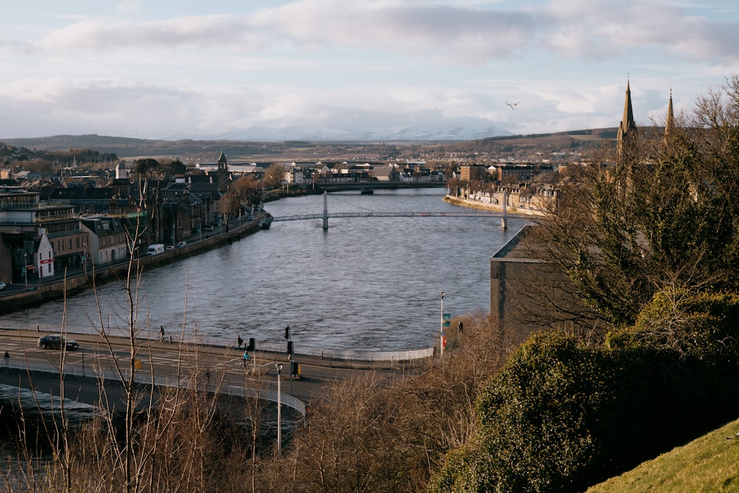 body of water near bridge under cloudy sky during daytime