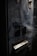 A close-up view of a worn, vintage vending machine with partial text reading 'einzigartig' on its surface. Smoking wisps trail across the machine, adding a mysterious and somewhat eerie effect. The machine appears old and slightly rusted, with dark blue and metallic tones.