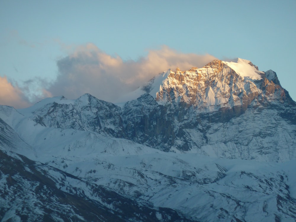 snow covered mountain under cloudy sky during daytime