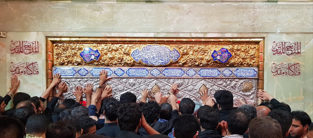 people gathering in front of white and blue floral wall