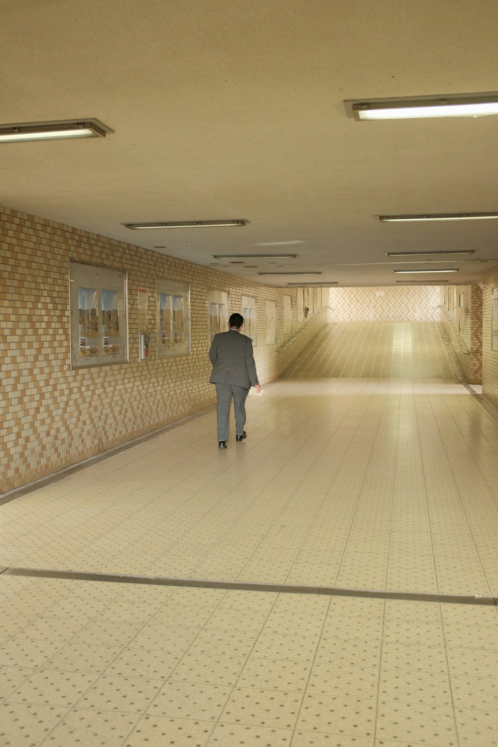 man in gray long sleeve shirt walking on hallway