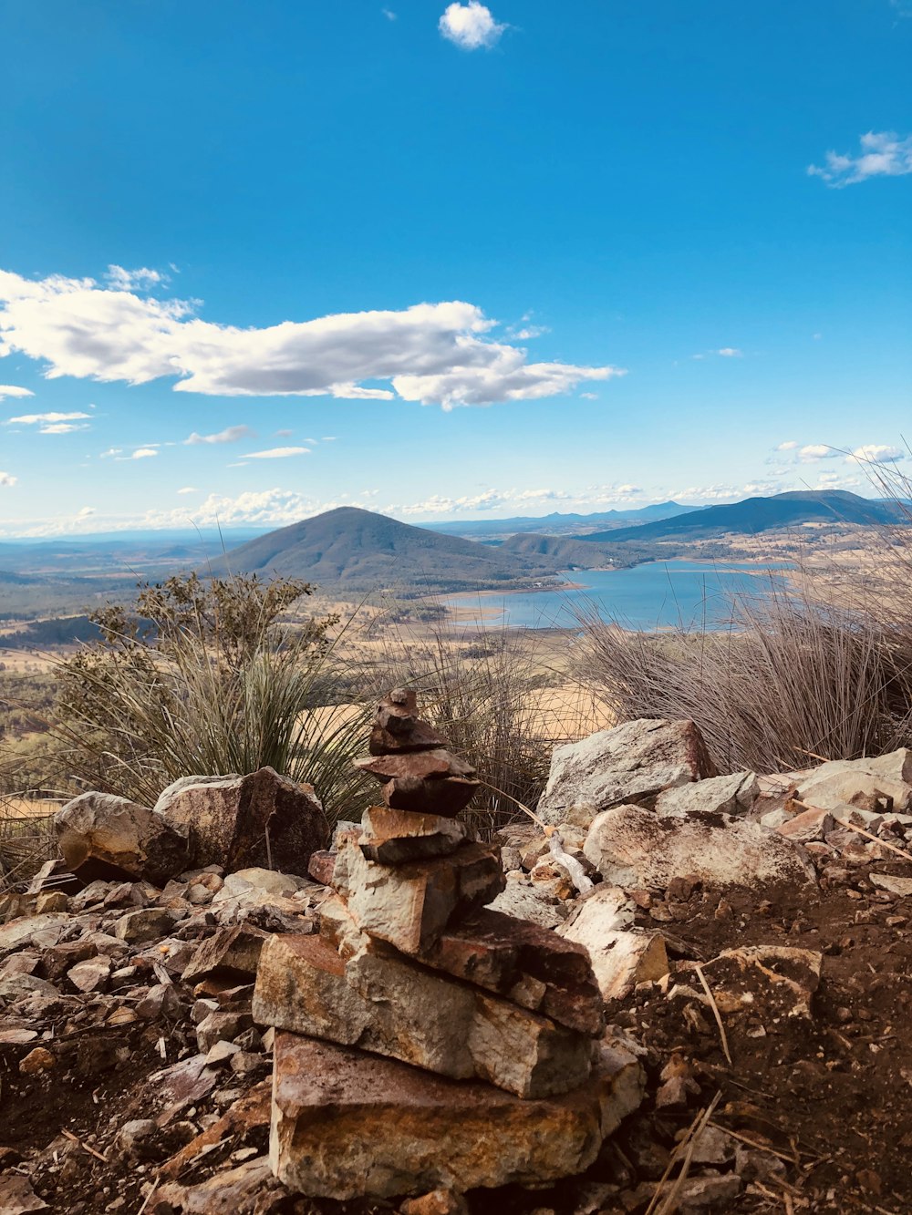 brown and gray rocks near body of water under blue sky during daytime