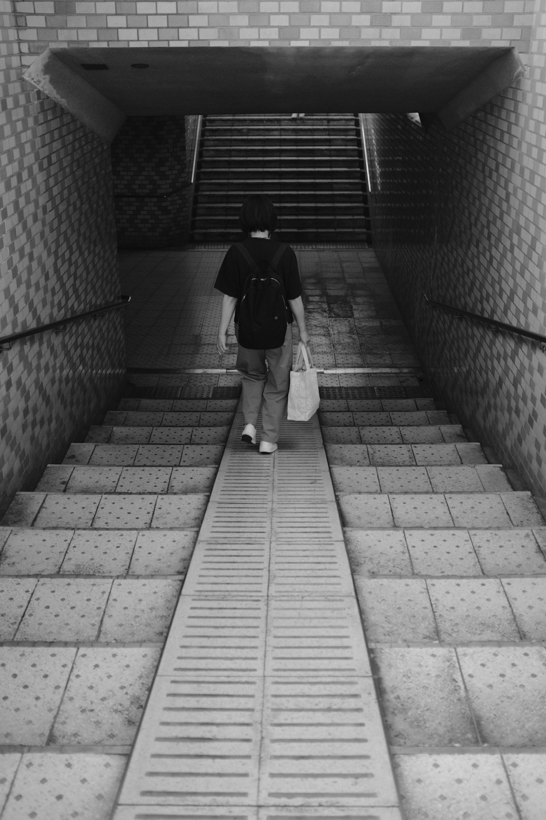 man in black jacket walking on hallway